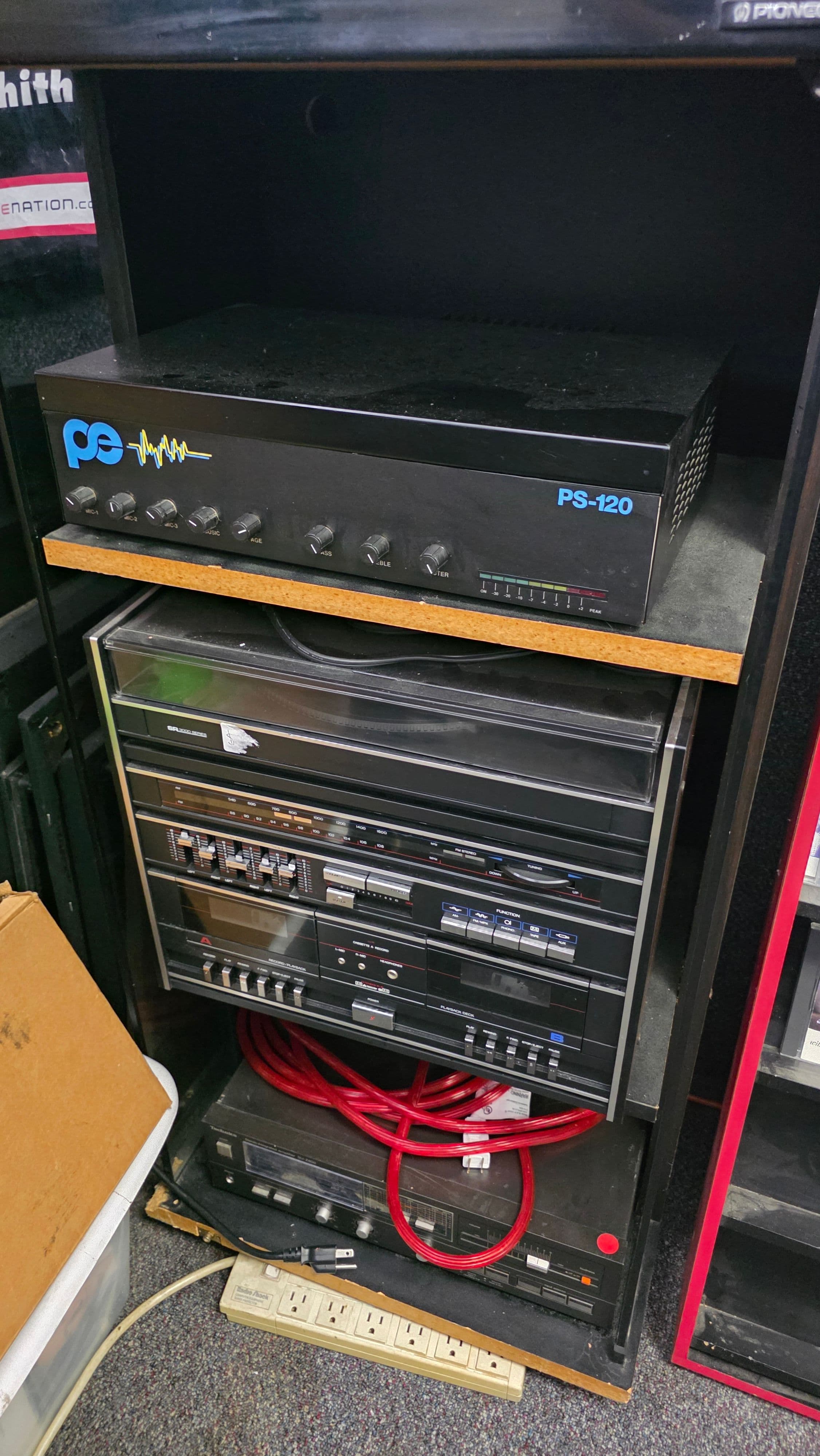 A PS-120 amplifier above a stacked component system with tuner, equaliser and twin cassette deck.