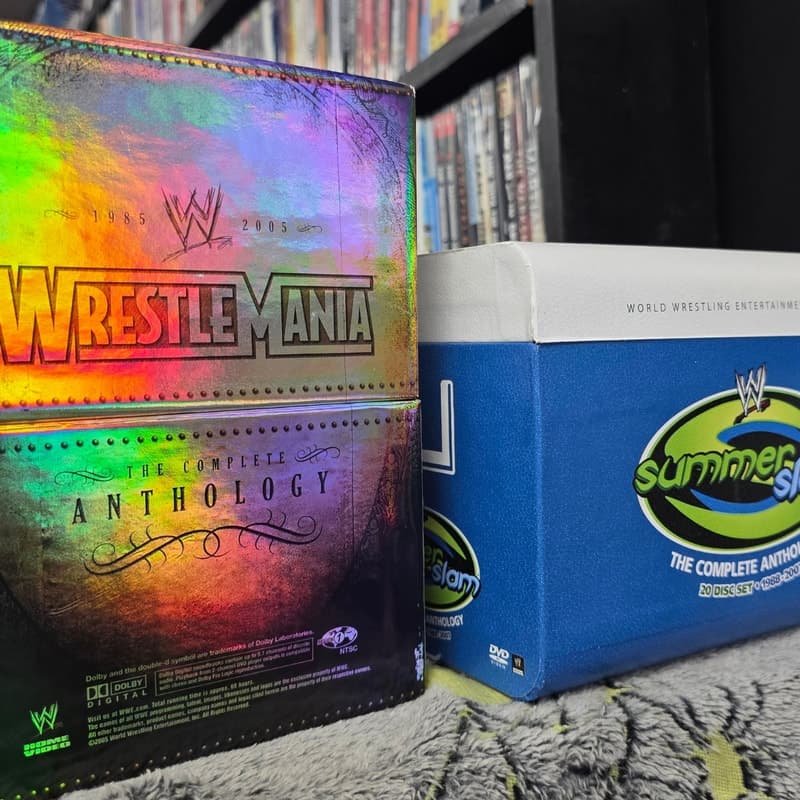 WWE WrestleMania and SummerSlam complete anthology box sets displayed on a shelf.